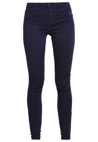 Jeans ajustados de denim índigo oscuro, con cintura alta, diseño de cinco bolsillos y una textura suave con costuras mínimas.