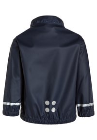 Veste imperméable marine avec un col montant, des poignets élastiques et des accents argentés réfléchissants. Présente un motif à points au dos.
