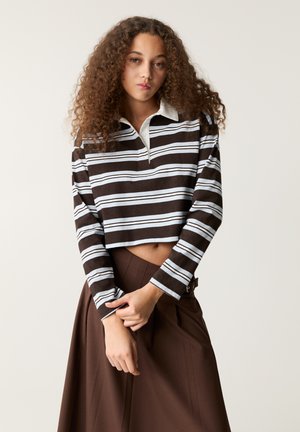 Brown and white striped long-sleeve crop polo shirt with a light blue collar, featuring a relaxed fit and soft texture.