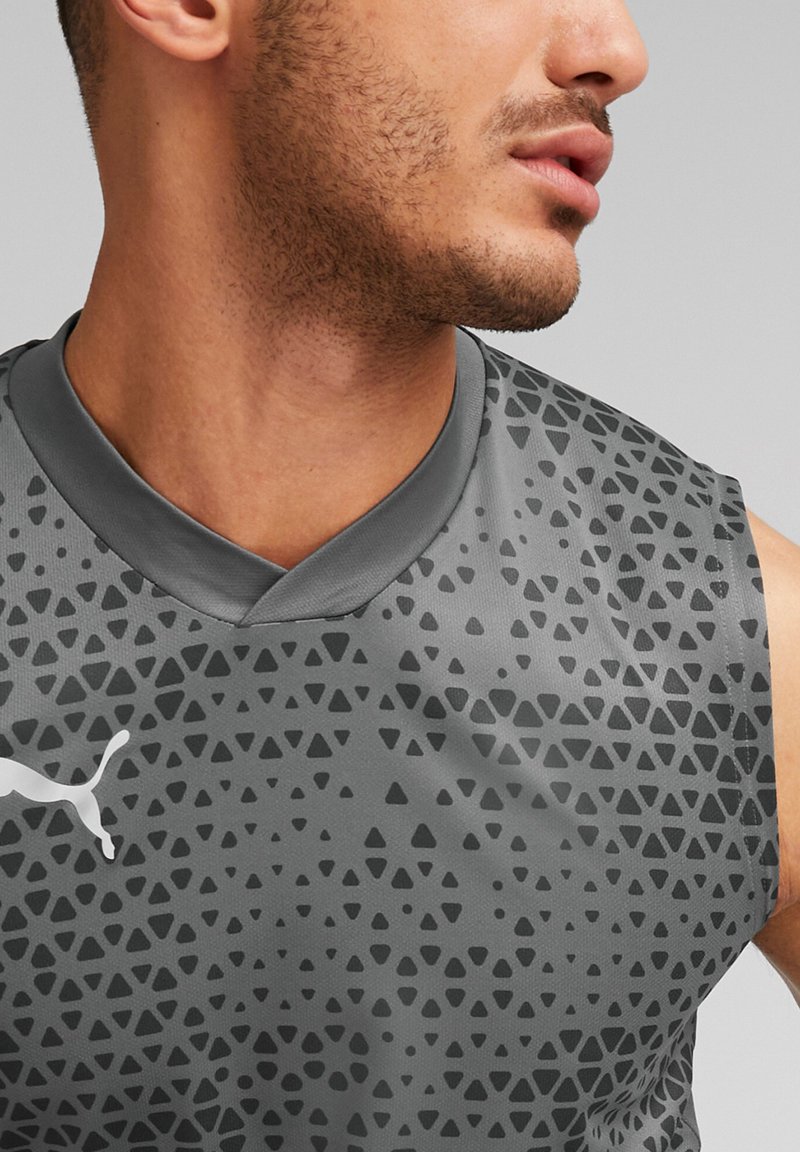 Grijs mouwloos sportshirt met een geometrisch driehoekpatroon, voorzien van een v-hals en een wit logo aan de linkerkant.