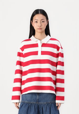 Rot-weiße gestreifte langärmelige Polohemd mit Kragen und Knopfverschluss, kombiniert mit einem Jeansrock. Glatte Stofftextur.