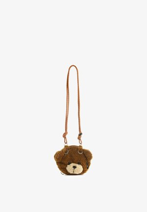 Bolso cruzado de peluche marrón con forma de oso de peluche, con hocico beige, ojos y nariz negros, colgado de una larga correa roja a rayas con nudos.