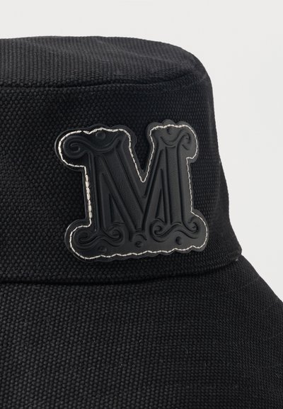 Μαύρο υφασμάτινο καπέλο τύπου bucket με ανάγλυφο, διακοσμητικό γράμμα "M" με λευκά ραφτά στο μπροστινό μέρος.
