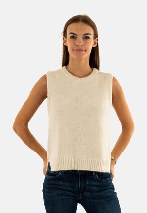 Maglione senza maniche di colore crema lavorato a maglia con scollatura e orlo a coste. Tessuto morbido, taglio dritto e spacchi laterali. Abbinato a jeans blu scuro.