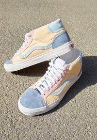 High-top sneakers gemaakt van gestructureerd corduroy in pastelkleuren - roze, blauw en geel - met witte veters en rubberen zolen.
