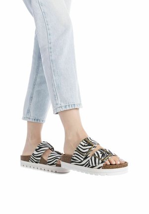 Chanclas de tiras a rayas en blanco y negro con doble correa, plantilla de corcho y suela gruesa de goma blanca. Diseño ligero y de punta abierta.