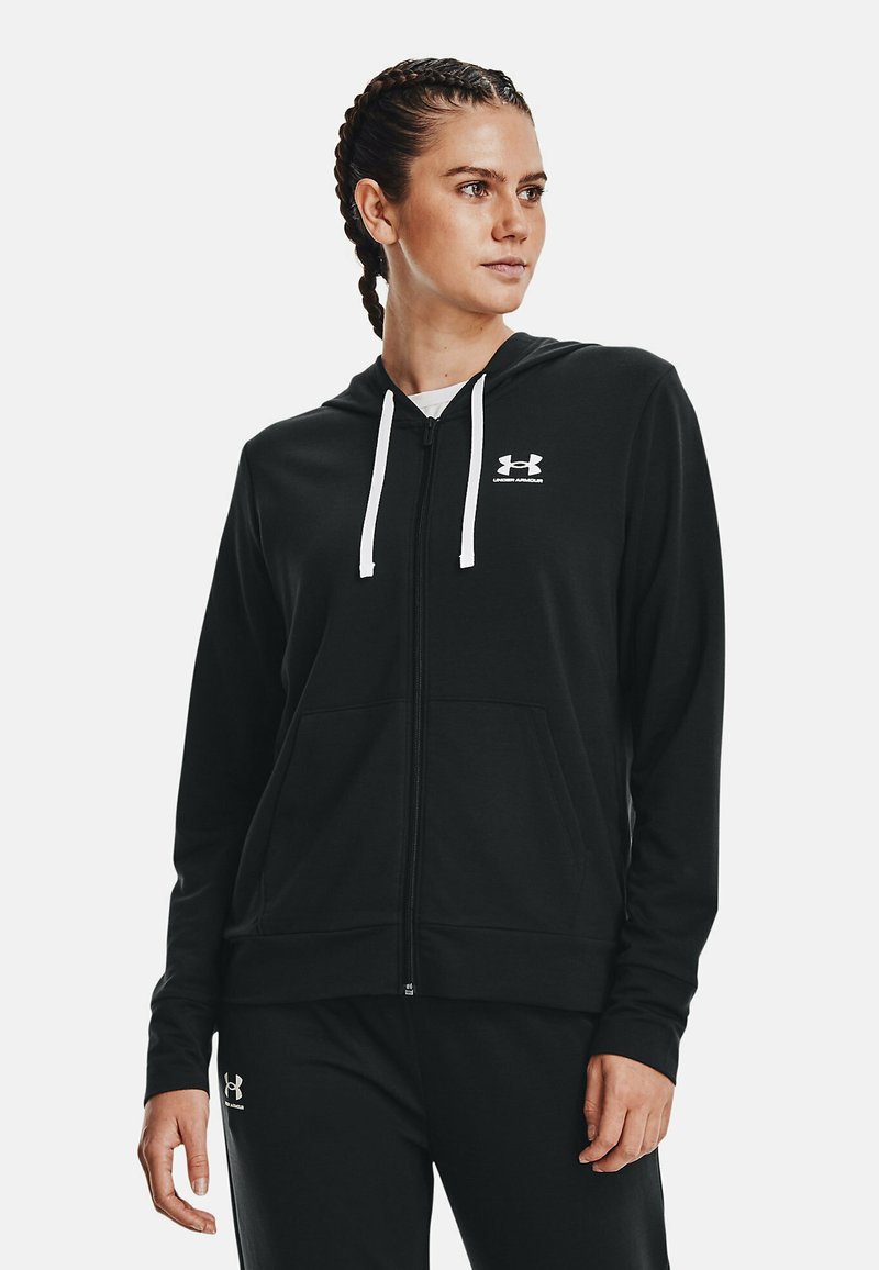 Sudadera con cremallera negra hecha de una tela suave, con cremallera frontal, cordones blancos y bolsillos laterales, con un logo en el pecho.