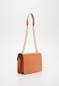 Pomarańczowa torebka o płaskim kształcie, z fakturą przypominającą skórę krokodyla, złotymi łańcuszkowymi rączkami oraz teksturowanym wykończeniem ze skóry. Zamknięcie na poziomy klapę.