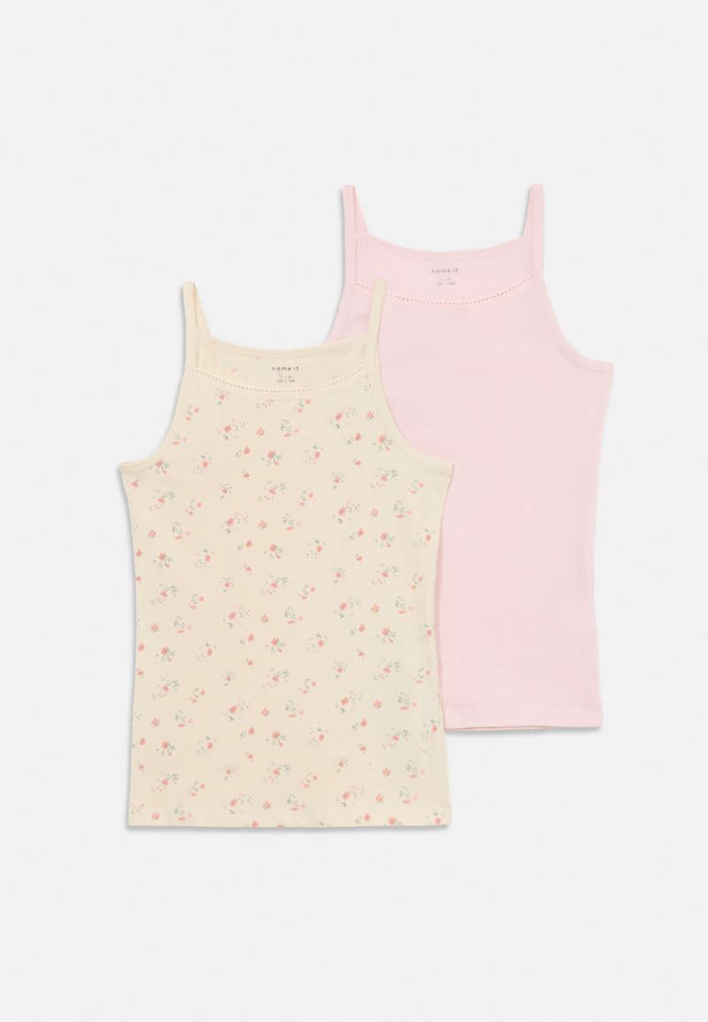 Two women’s tank tops: one cream with small floral print, the other solid pink. Both feature thin spaghetti straps and a soft texture.