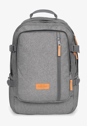 Sac à dos en tissu gris de forme rectangulaire, avec des zips, des accents en cuir, des bretelles ajustables et une finition texturée.