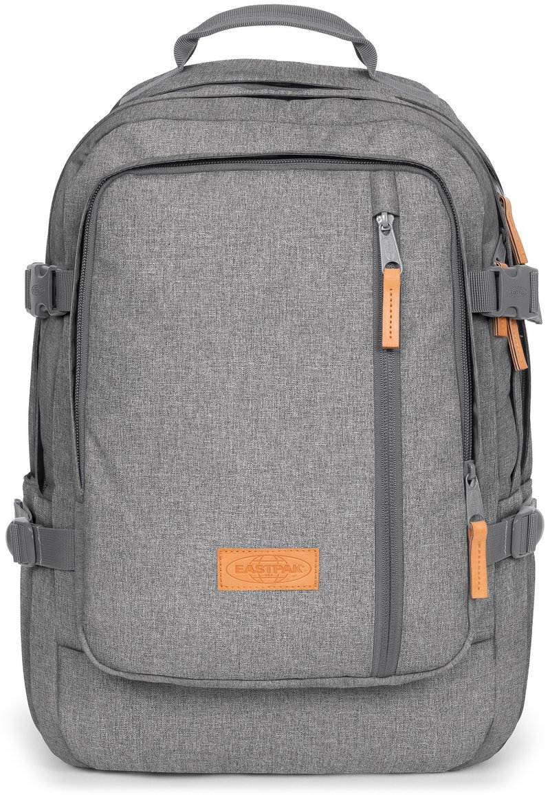 Zaino in tessuto grigio dalla forma rettangolare, dotato di zip, dettagli in pelle, spallacci regolabili e una finitura testurizzata.