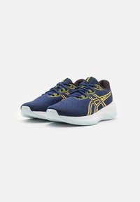Scarpe sportive blu navy con tomaia in mesh traspirante, dettagli in giallo neon, lacci piatti e suola in gomma leggera.
