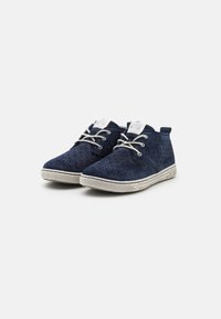 Scarpe in suede blu navy con design perforato, suola in gomma bianca e lacci grigi chiari. Presentano un piccolo etichetta del marchio sulla linguetta.