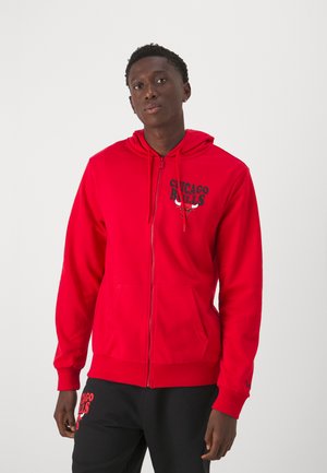 Rød zip-hættejakke med kænguru-lomme og trykt "Chicago Bulls" logo i sort. Blødt materiale med ribbede manchetter og kant.