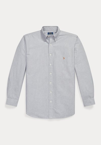 Chemise bleu clair à manches longues avec col boutonné et petit logo brodé sur la poitrine gauche.