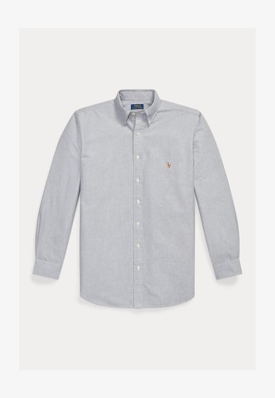 Chemise bleu clair à manches longues avec col boutonné et petit logo brodé sur la poitrine gauche.