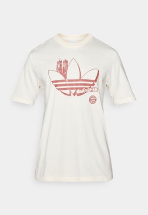 Κρεμ βαμβακερό T-shirt με κόκκινο γραφικό, που απεικονίζει λογότυπο με τρία φύλλα και τον ορίζοντα του Μονάχου, κοντά μανίκια και στρογγυλή λαιμόκοψη.
