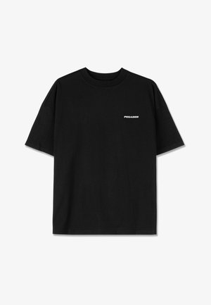 T-shirt en coton noir à manches courtes, col rond, avec un petit logo texte blanc "PEGADOR" sur la poitrine. Texture lisse, coupe décontractée.