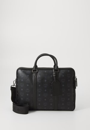 Black leather briefcase with embossed logo pattern, zip closure, top handles, detachable strap, and hang tag; smooth and textured surfaces.