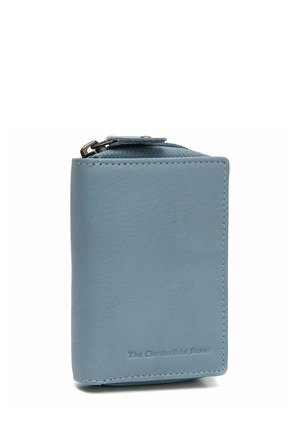 Portefeuille en cuir bleu clair avec fermeture éclair, coutures visibles et logo embossé "The Chesterfield Brand" sur le devant.