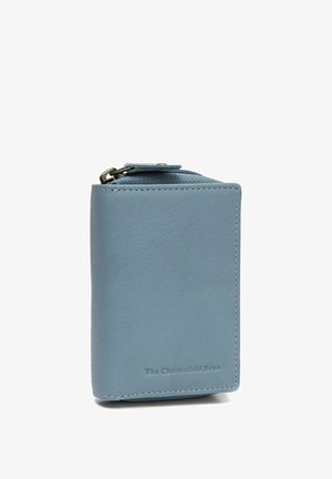 Portefeuille en cuir bleu clair avec fermeture éclair, coutures visibles et logo embossé "The Chesterfield Brand" sur le devant.