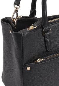 Zwarte leren handtas met een gestructureerde afwerking, twee met rits afsluitbare compartimenten, gouden hardware en korte handvatten. Beschikt over een zijvak met rits.
