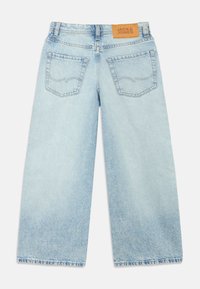 Φαρδιά παντελόνια τζιν σε ανοιχτό μπλε χρώμα, κατασκευασμένα από denim, με μια καφέ δερμάτινη ετικέτα στη μέση, δύο πίσω τσέπες και ξεφτισμένο τελείωμα.