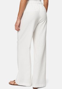 White, wide-leg pants made from a lightweight fabric, featuring an elastic waistband and back pockets. Smooth texture and casual design.
