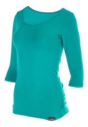 Turquoise long-sleeve top made of stretchy material. Features a scoop neckline and gathers on the sides. Tag displays brand name.
