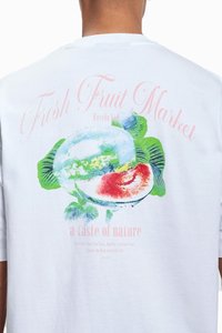 Hvit bomulls t-skjorte med et fargerikt frukttrykk av vannmelon og blader, med teksten "Fresh Fruit Market" i rosa og grønt.