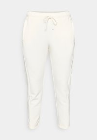 Φωτεινό κρεμ παντελόνι τύπου jogger κατασκευασμένο από απαλό ύφασμα, με ελαστική μέση και κορδόνι, πλαϊνές τσέπες και στενά τελειώματα στα πόδια.