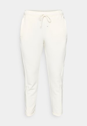 Helle cremefarbene Jogginghosen aus weichem Stoff, mit elastischem Bund und Kordelzug, seitlichen Taschen und zulaufenden Beinen.