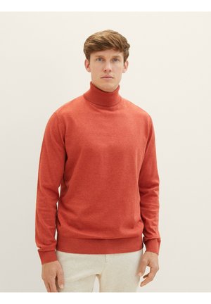 Pull à col roulé rouge avec des manches longues, col et poignets côtelés, fabriqué dans un tissu lisse et texturé. Le teint est neutre.