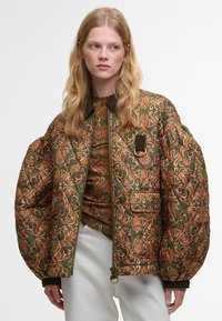 Casaco verde acolchoado com um padrão floral laranja ornamental, apresentando fecho com zíper, um grande colarinho e um grande bolso frontal.