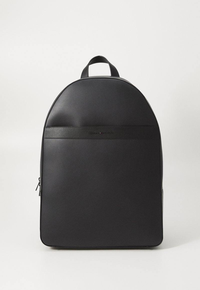 Sac à dos noir élégant avec panneaux lisses et texturés, poignée supérieure et fermeture éclair latérale sur fond blanc uni.