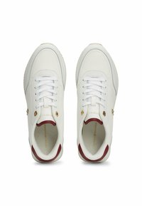 Witte leren sneakers met een gladde textuur, voorzien van gouden hardware-accenten en een kastanjebruine hiel. Vetersluiting, ronde neus.
