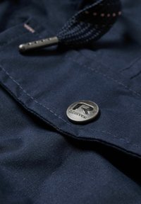 Navy blue fabric with a smooth texture, featuring a silver metal snap button embossed with "REINTEX" and a braided drawstring.