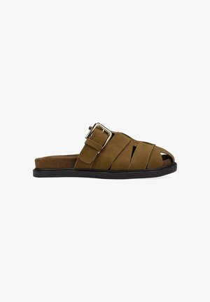 Sandalia tipo slide marrón de punta abierta con suela negra y una gran hebilla plateada en una amplia correa ajustable sobre el pie.