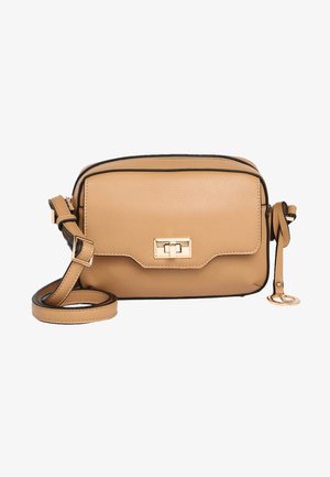 Beige Leder-Umhängetasche mit Frontklappe, goldfarbenem Drehverschluss, verstellbarem Riemen und dekorativem goldfarbenem Anhänger an der Seite.