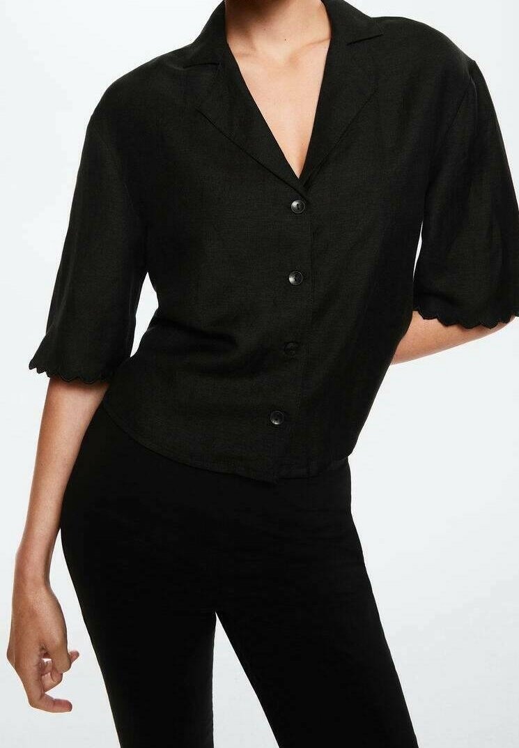Schwarze Bluse mit Kragen und kurzen, gewellten Ärmeln, mit schmaler Passform und sechs schwarzen Knöpfen auf der Vorderseite, aus strukturiertem Stoff gefertigt.