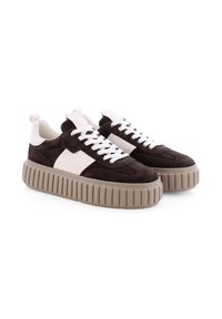 Bruine suède sneakers met witte accenten, dikke beige rubberzool, afgeronde neus en klassiek vetersluiting ontwerp. Versterkte hiel en merkdetail.
