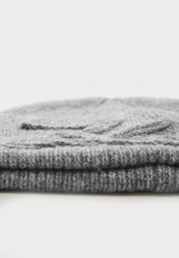 Grey knitted beanie hat folded at the brim, featuring a textured leaf pattern and a soft, warm material.