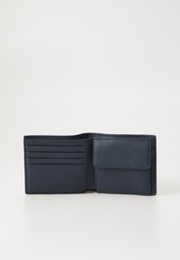 Carteira de couro azul-marinho com vários compartimentos para cartões, um bolso com fecho de botão e um acabamento texturizado. Design retangular compacto.