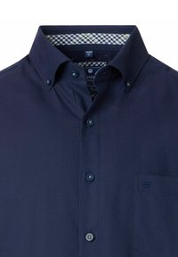 Marineblauw overhemden met knoopsluiting in een geweven stof, voorzien van een geruit detail aan de binnenkant van de kraag en een zak aan de linkerkant.