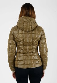 Giacca a vento verde oliva con texture a trapunta, cappuccio e design aderente. Il materiale appare lucido e liscio.