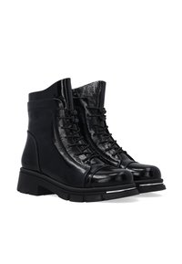 Schwarze Leder-Ankle-Boots mit glänzender Oberfläche, ausgestattet mit einer Schnürung, gepolstertem Kragen und einer robusten Gummisohle mit Akzentdetails.