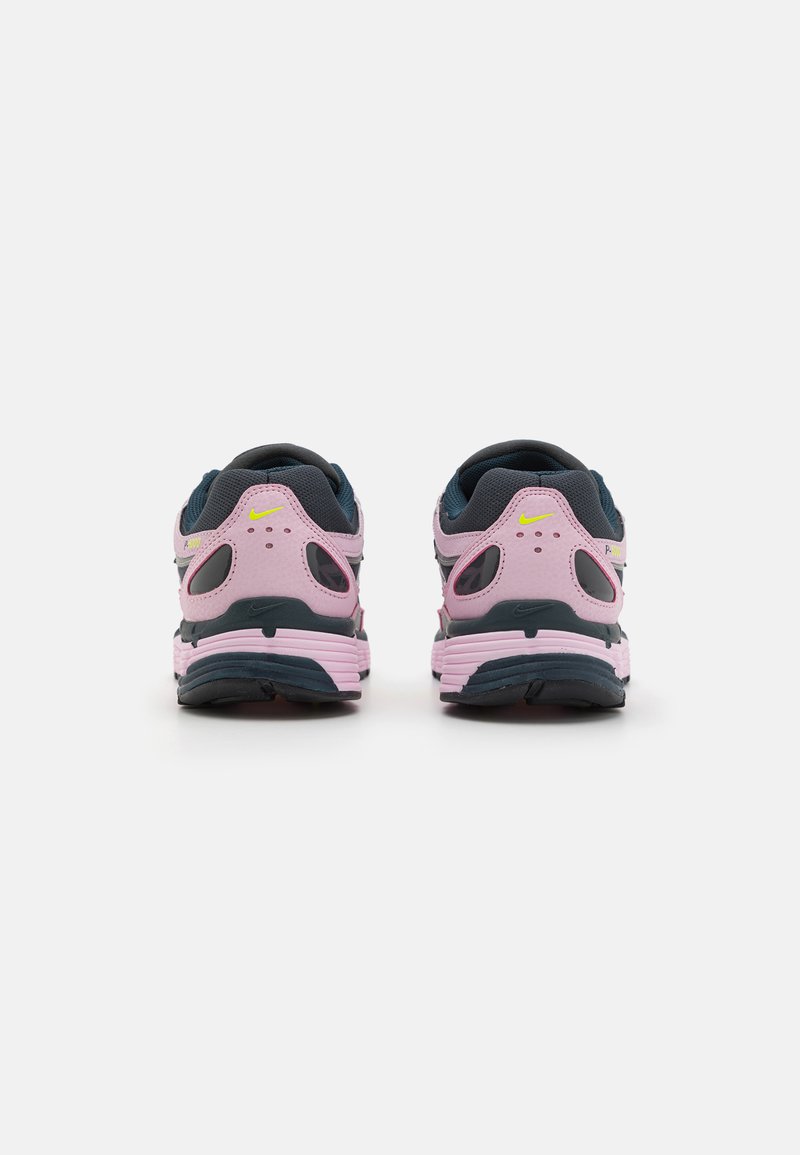 Nike hardloopschoenen met een roze lichaam, marineblauwe accenten en gele branding. Beschikt over ventilatiegaten en een gevoerde zool. Achteraanzicht.