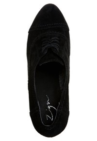 Svart mocka oxfordskor med spetsig tå, med mörka snören och subtila sömmar. Insidan visar en silverlogotyp på innersulan.