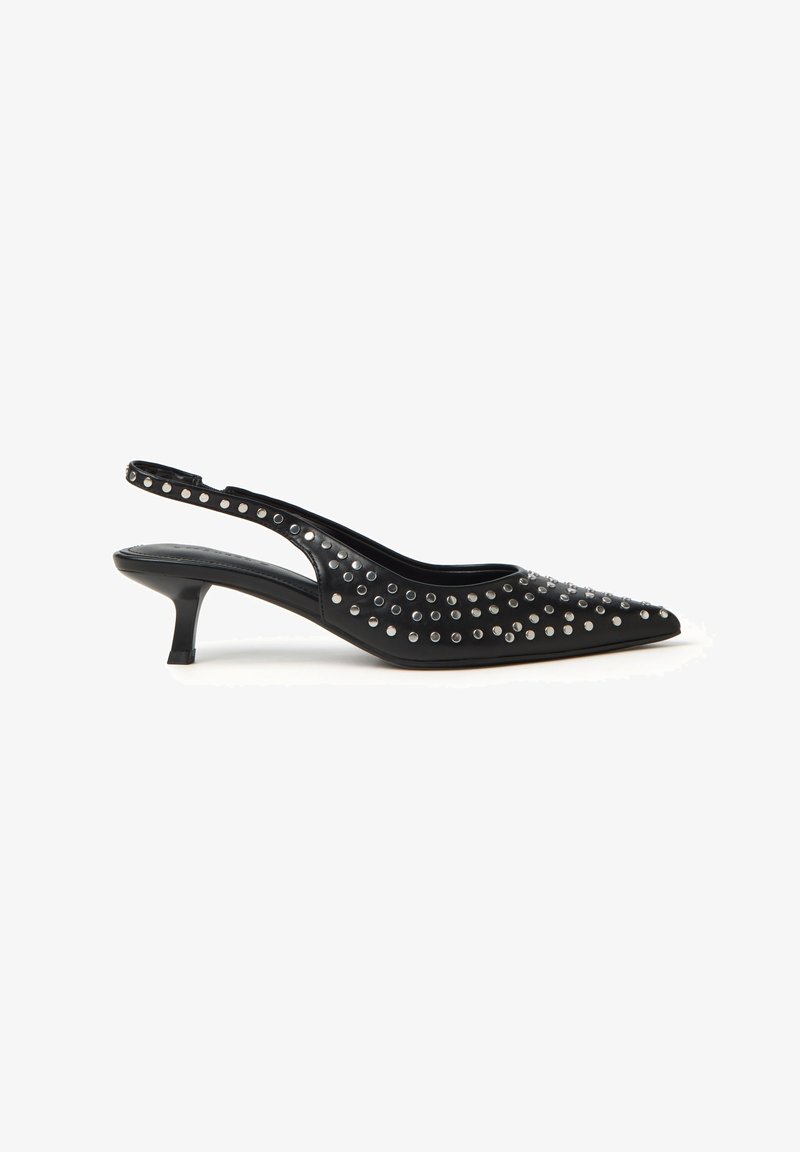 Chaussure à talon kitten noir en cuir, à bout pointu et à bride slingback, ornée de clous argentés sur le dessus et la bride, présentée sur un fond blanc.
