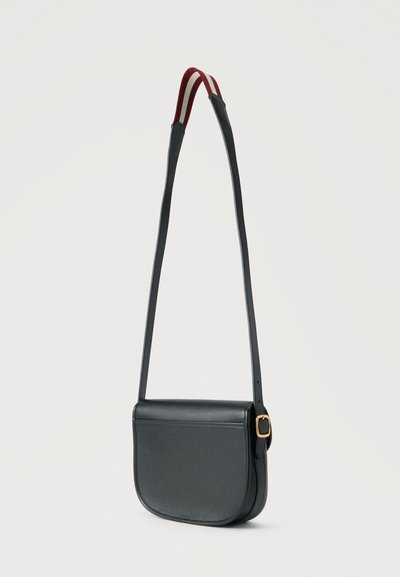 Μαύρη δερμάτινη τσάντα χιαστί με στρογγυλερό καπάκι, χρυσή αγκράφα και ρυθμιζόμενο λουρί με μαξιλαράκι ώμου σε κόκκινο και λευκό ρίγες.